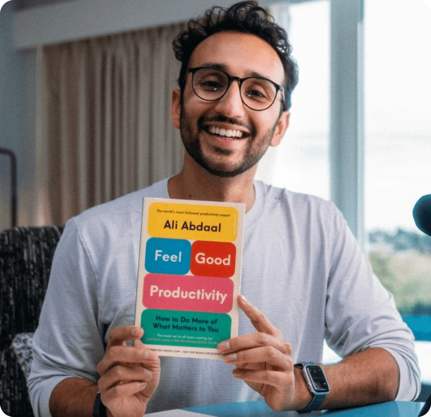 Ali Abdaal holding Feel-Good Productivity